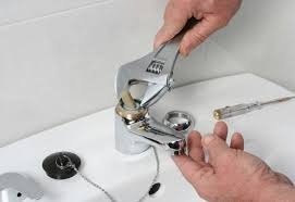 Plomero reparando grifo de lavamanos